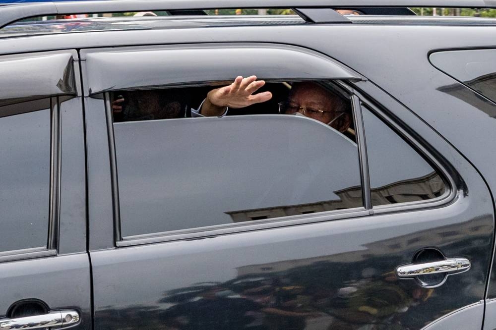 Jailed former prime minister Datuk Seri Najib Razak waves to his supporters as he leaves the Kuala Lumpur Court Complex, August 25, 2022. — Picture by Firdaus Latif