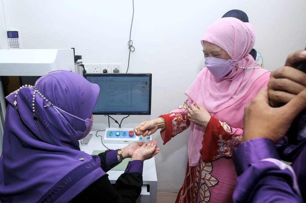 Majlis Amanah Rakyat (MARA) chairman Datuk Seri Azizah Mohd Dun (right) looks at a ring design after officially the opening gold shop Nur Jannah Sdn Bhd in Kuala Pilah August 25, 2022. — Bernama pic