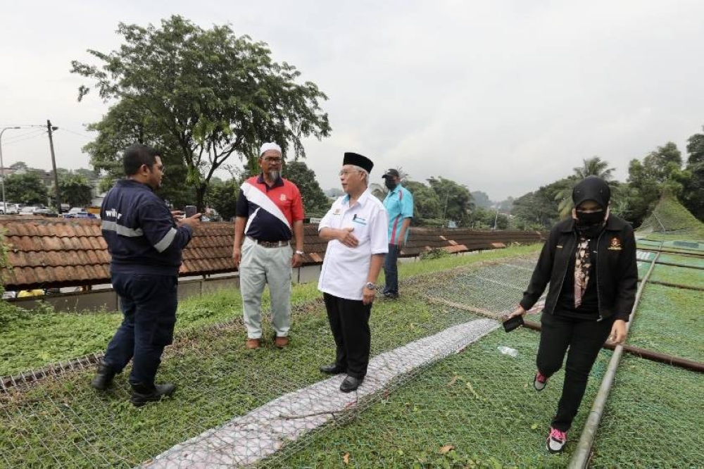 Pasir Gudang MP Hassan Abdul Karim (in white) inspects the damaged school fence at Sekolah Menengah Kebangsaan Pasir Gudang 3 in Pasir Gudang August 26, 2022. — Picture by Ben Tan