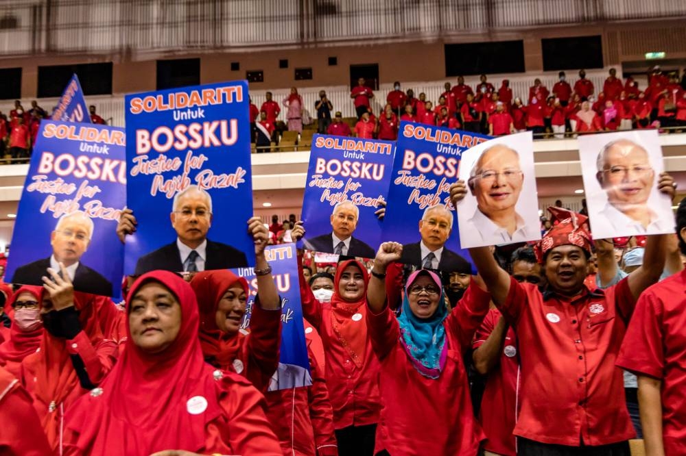 Umno members holding up placards in support of former Prime Minister Datuk Seri Najib during the Umno special briefing for divisional committee members and leaders at Umno headquarters in Kuala Lumpur World Trade Centre (WTCKL), August 27, 2022. — Picture by Firdaus Latif