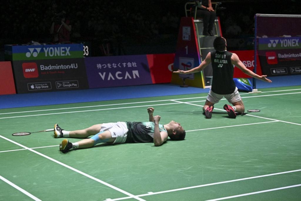 Aaron Chia (left) and Soh Wooi Yik of Malaysia celebrate their victory over Mohammad Ahsan and Hendra Setiawan of Indonesia in the men's doubles final match at the World Badminton Championships in Tokyo, August 28, 2022. — AFP pic