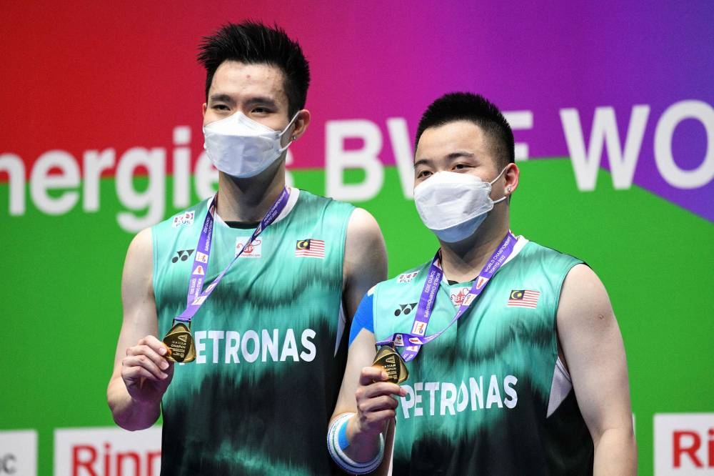 Gold medal winners Aaron Chia and Soh Wooi Yik (left) of Malaysia pose on the podium after their victory in the men's doubles final at the World Badminton Championships in Tokyo on August 28, 2022. — AFP pic