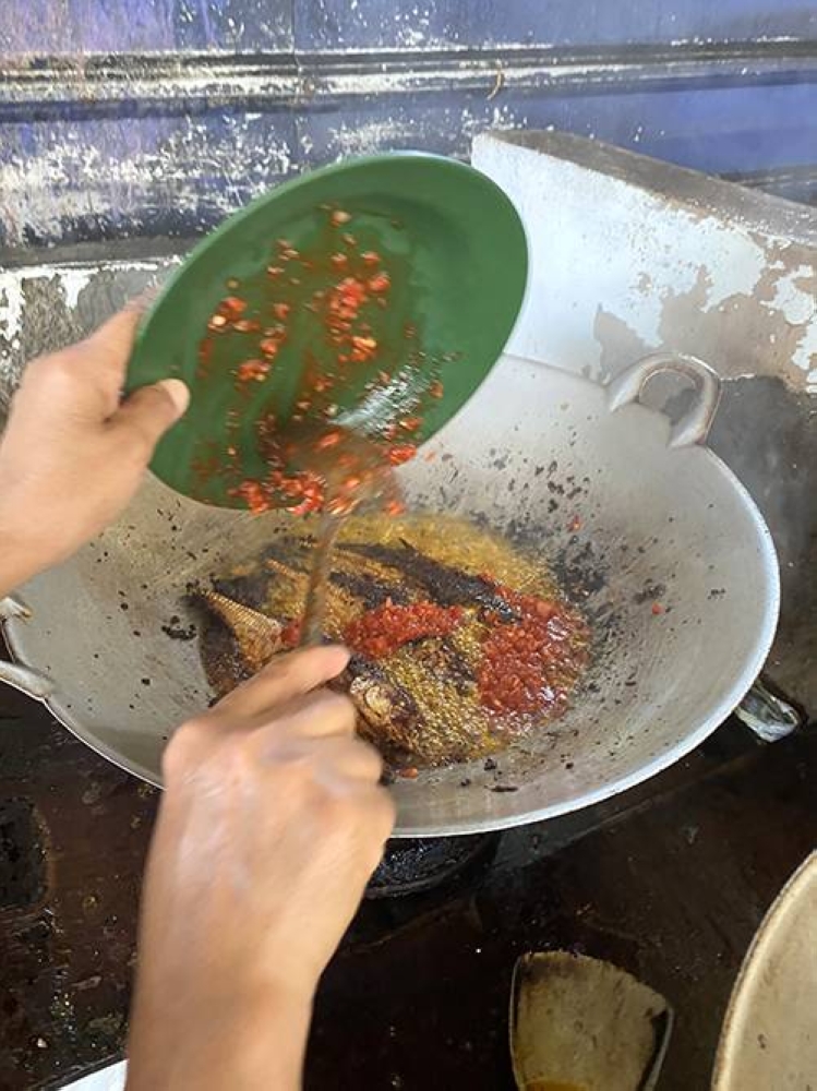 They add extra spice paste inside the wok to also fry till it becomes fragrant, toasty bits.