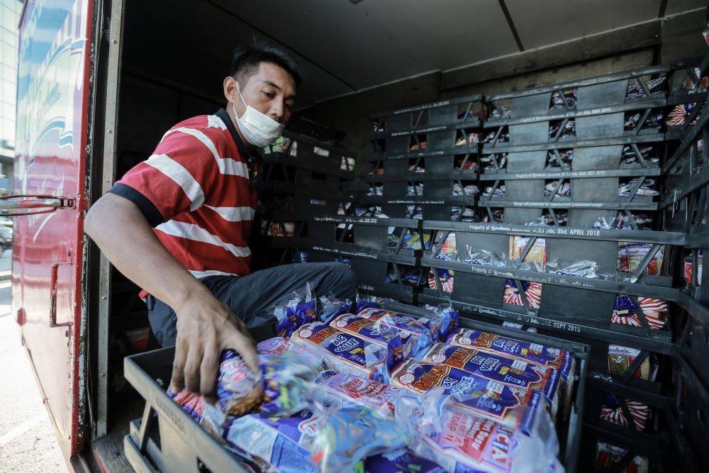 A Gardenia staff unloads fresh loaves of bread at a convenience store in Petaling Jaya March 25, 2020. - Picture by Ahmad Zamzahuri