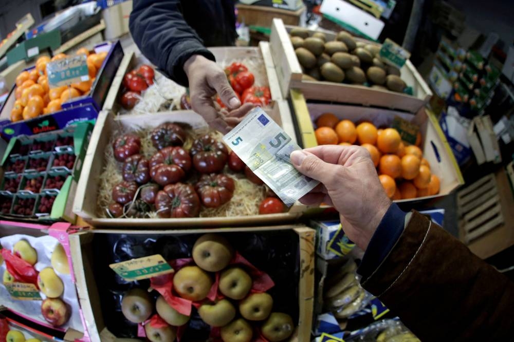 A shopper pays with a euro bank note in a market in Nice, France, April 3, 2019. — Reuters pic