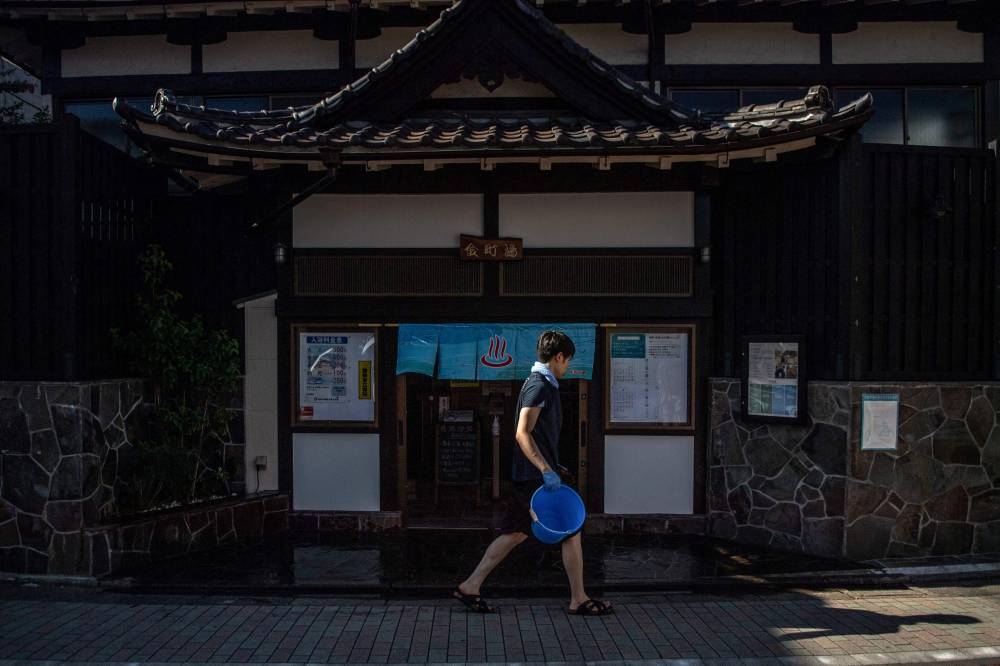 This picture taken on July 30, 2022 shows a staff member walking past the entrance of the Kanamachi, which is a 