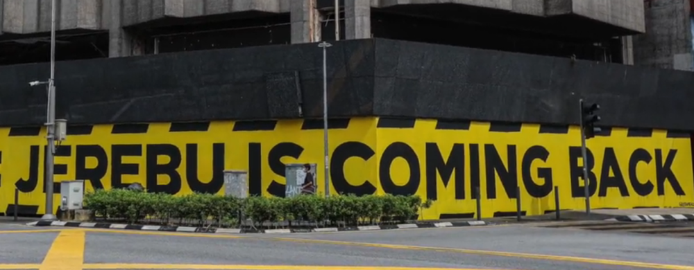 Unlike his usual methods of sharing satirical graphic designs on social media, local graphic designer and activist Fahmi Reza took to the side of the Wisma Megah building in Jalan Tun Tan Cheng Lock in KL to paint a cautionary mural. — Screenshot via Twitter/ Fahmi Reza