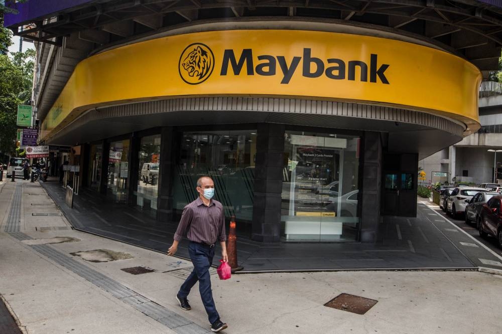 Pedestrians walk past a Maybank branch in Kuala Lumpur, July 9, 2021. — Picture by Firdaus Latif