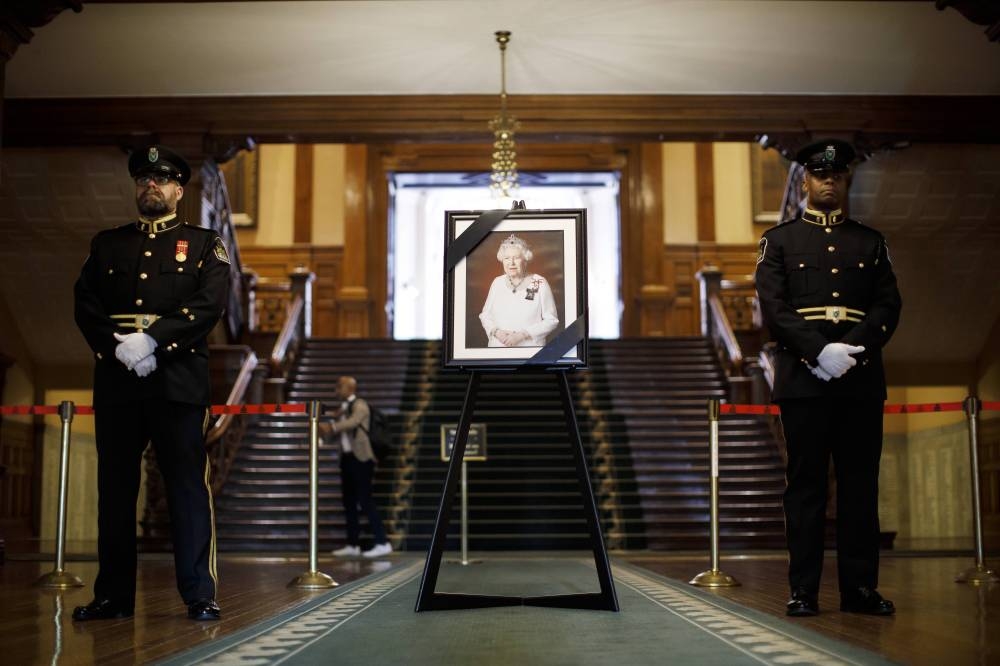 A portrait of Queen Elizabeth II is draped with a black ribbon amongst books of condolences for the public to sign, in Queen's Park Legislative Assembly of Ontario, on September 9, 2022 in Toronto, Canada. — AFP pic