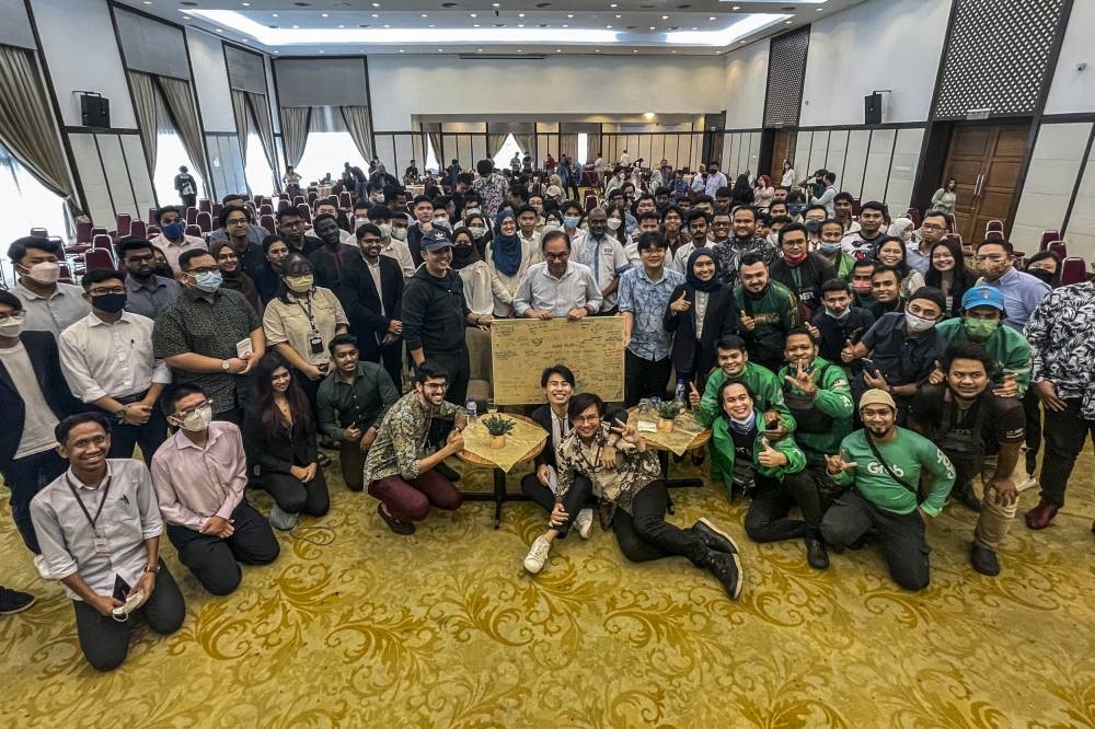 Opposition Leader Datuk Seri Anwar Ibrahim taking a photograph with the audience during the town hall session with youths at Universiti Malaya Alumni Centre September 11, 2022. — Picture by Hari Anggara