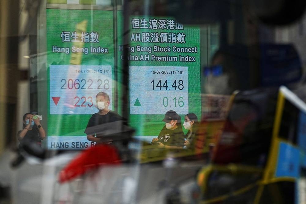 A vehicle drives past a screen displaying the Hang Seng stock index at Central district, in Hong Kong, China July 19, 2022. — Reuters pic