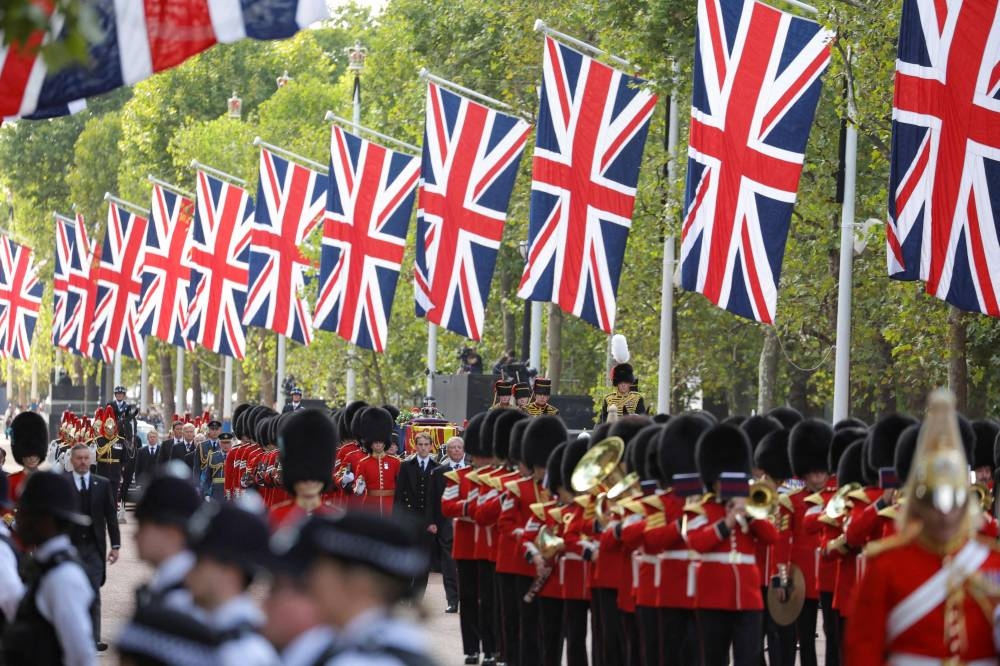 The coffin of Queen Elizabeth II, adorned with a Royal Standard and the Imperial State Crown and pulled by a Gun Carriage of The King's Troop Royal Horse Artillery, during a procession from Buckingham Palace to the Palace of Westminster, in London September 14, 2022. — Marko Djurica/Pool/AFP pic