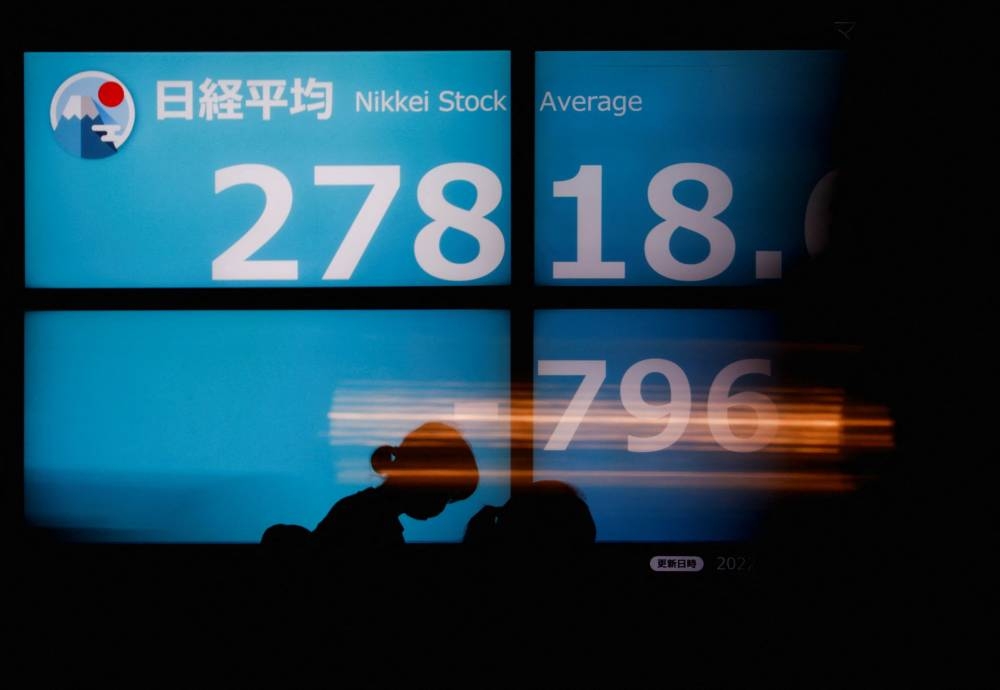 People walk past an electric board showing Japan's Nikkei share average in Tokyo September 14, 2022. — Reuters pic