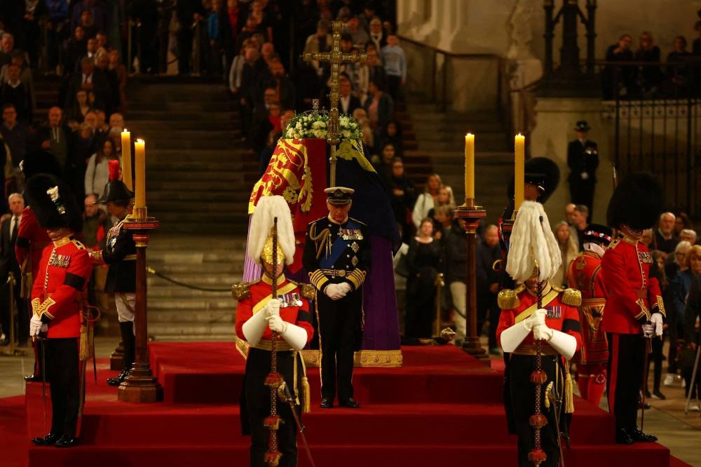 Britain’s King Charles III stands guards as he takes part in a vigil around the coffin of Queen Elizabeth II, draped in the Royal Standard with the Imperial State Crown and the Sovereign’s orb and sceptre, lying in state on the catafalque in Westminster Hall, at the Palace of Westminster in London on September 16, 2022, ahead of her funeral on Monday. — AFP pic