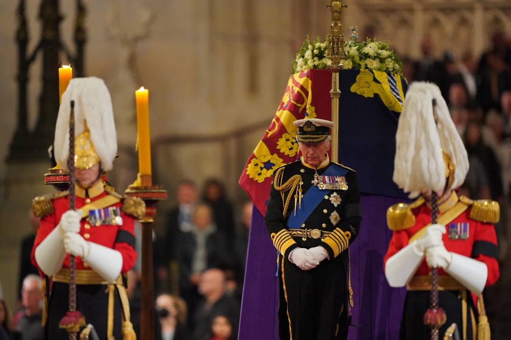 Britain’s King Charles III attends a vigil around the coffin of Queen Elizabeth II, draped in the Royal Standard with the Imperial State Crown and the Sovereign’s orb and sceptre, lying in state on the catafalque in Westminster Hall, at the Palace of Westminster in London on September 16, 2022, ahead of her funeral on Monday. — AFP pic