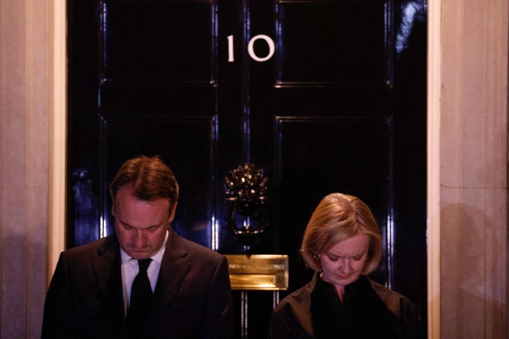 Britain's Prime Minister Liz Truss stands on the steps of 10 Downing Street joining in a National Moment of reflection to show her respect to the late Queen Elizabeth II, in London on September 18, 2022, ahead of her State Funeral on Monday. — AFP pic