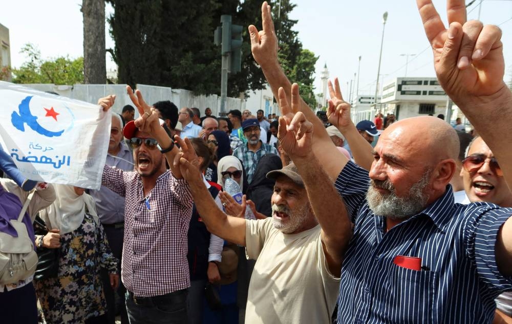 Supporters of Tunisia's Islamist opposition party Ennahda gesture as they protest in support of the party leaders, Rached Ghannouchi and Ali Larayedh, who are facing questioning by anti-terrorism police in Tunis,Tunisia September 19, 2022. — Reuters pic