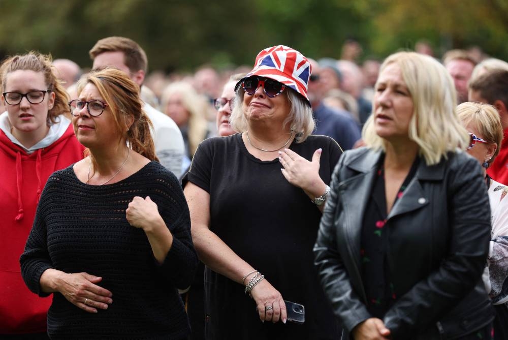 Members of the public react as the procession makes its way at The Long Walk in Windsor on September 19, 2022, during the final journey to Windsor Castle after the State Funeral Service of Britain's Queen Elizabeth II. — Alex Pantling/Pool/AFP pic