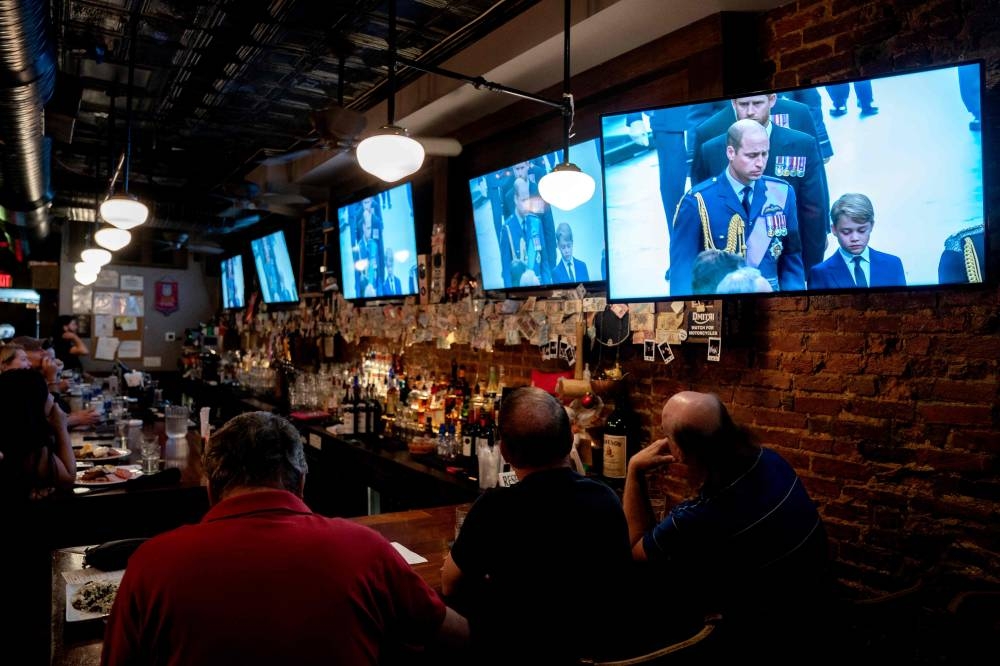 People watch the state funeral of Queen Elizabeth II at The Queen Vic pub in Washington, DC, on September 19, 2022. — AFP pic