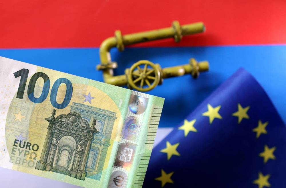 A model of a natural gas pipeline, a Euro banknote and a torn European Union flag are placed on a Russian flag in this illustration taken September 7, 2022. — Reuters pic