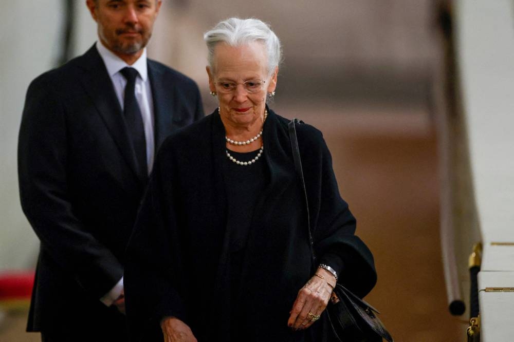 Queen Margrethe II of Denmark (right) and Crown Prince Frederik (left) arrive to pay their respects at the coffin of Queen Elizabeth II, Lying in State inside Westminster Hall, at the Palace of Westminster in London on September 18, 2022. — John Sibley/Pool/AFP pic