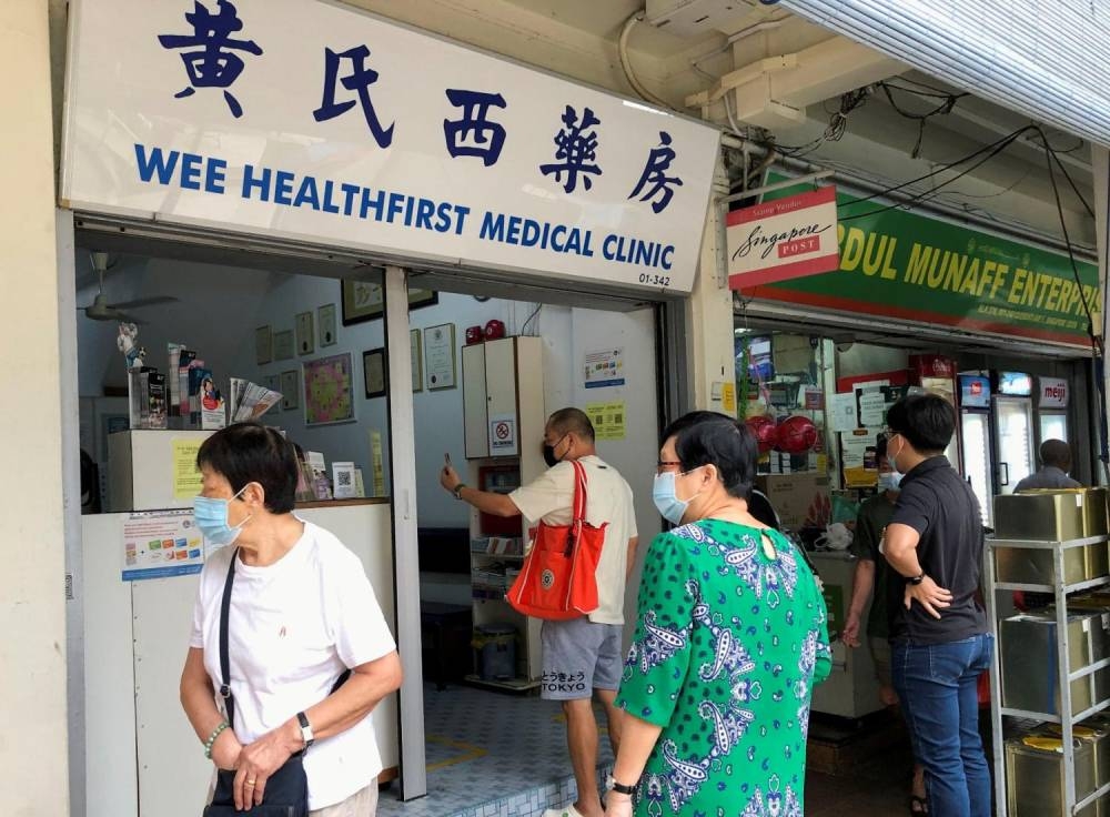 People waiting outside a general practitioner clinic in Clementi. ― Reuters pic