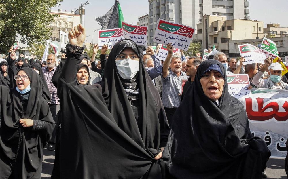 Women and men chant slogans as they march in a pro-hijab rally in Iran's capital Tehran on September 23, 2022. — AFP pic