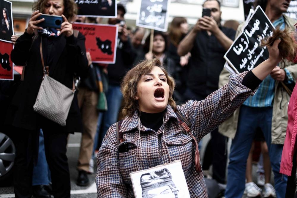 A woman cuts her hair during a demonstration in support of Mahsa Amini in front of the Iranian embassy in Brussels, on September 23, 2022, following the death of an Iranian woman after her arrest by the country’s morality police in Tehran.― AFP pic