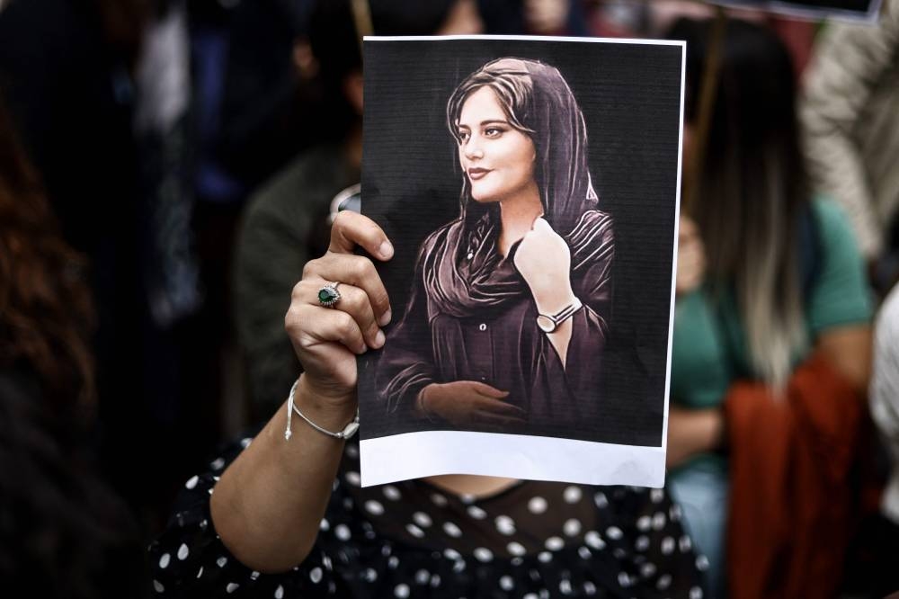 A protester holds a portrait of Mahsa Amini during a demonstration in her support in front of the Iranian embassy in Brussels on September 23, 2022, following the death of an Iranian woman after her arrest by the country’s morality police in Tehran.― AFP pic