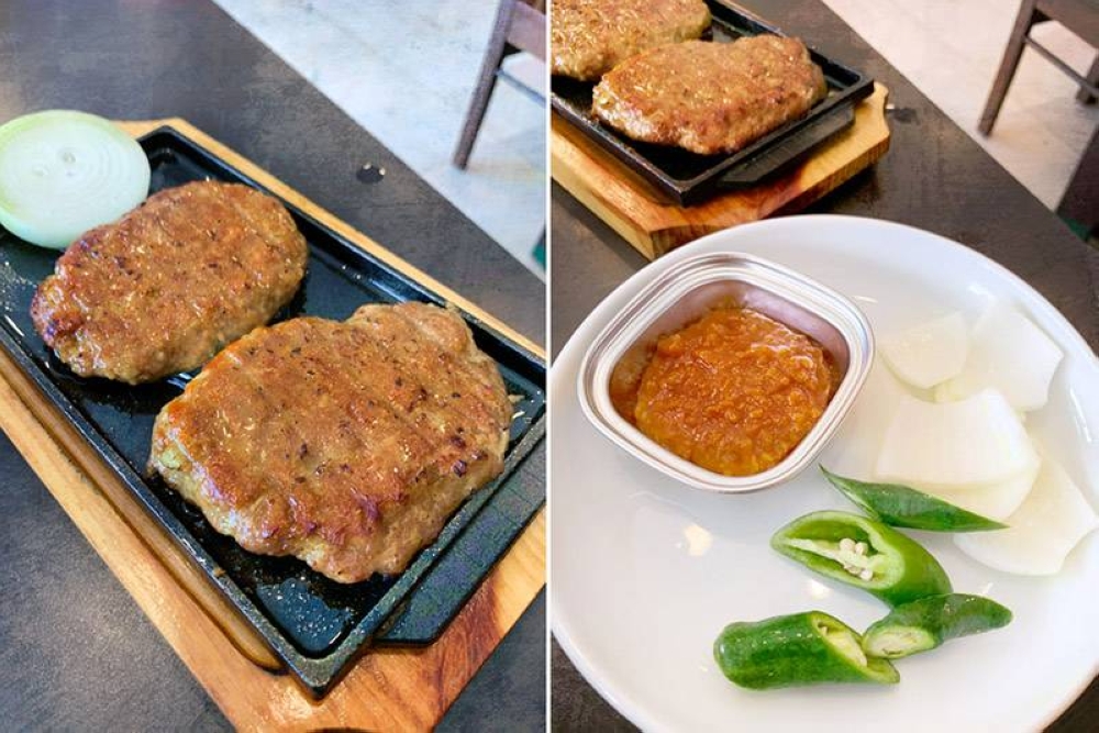 Enjoy 'Deji Tteok-Galbi' (tender grilled pork) with some raw onions, sliced green chili peppers and 'ssamjang' (dipping sauce).