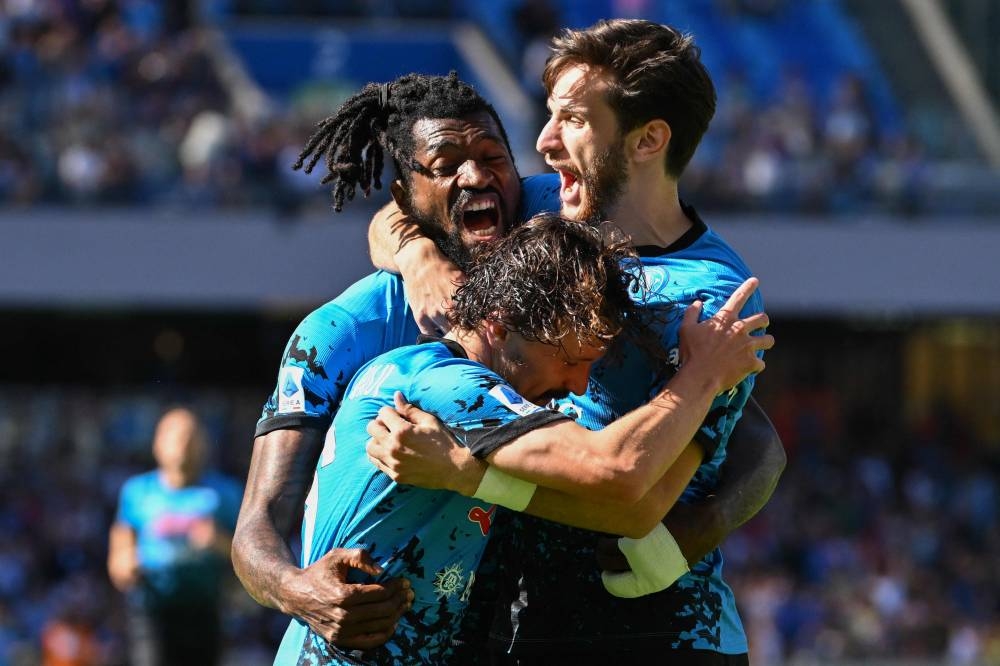 Napoli’s Cameroonian midfielder Andre Zambo Anguissa (left) celebrates with Napoli’s Georgian forward Khvicha Kvaratskhelia (right) and Napoli’s Portuguese defender Mario Rui after scoring his second goal during the Italian Serie A football match between Napoli and Torino on October 1, 2022 at the Diego-Maradona stadium in Naples. ― AFP pic