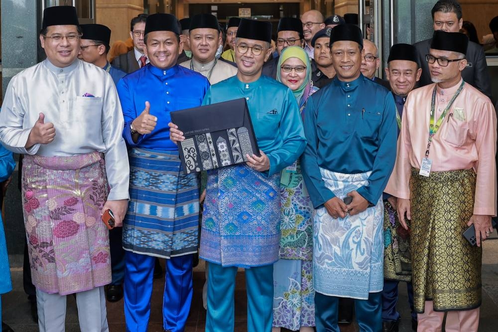 Finance Minister Datuk Seri Tengku Zafrul Abdul Aziz (centre) holds up the Budget 2023 document outside the Finance Ministry in Putrajaya, October 7, 2022. — Picture by Shafwan Zaidon