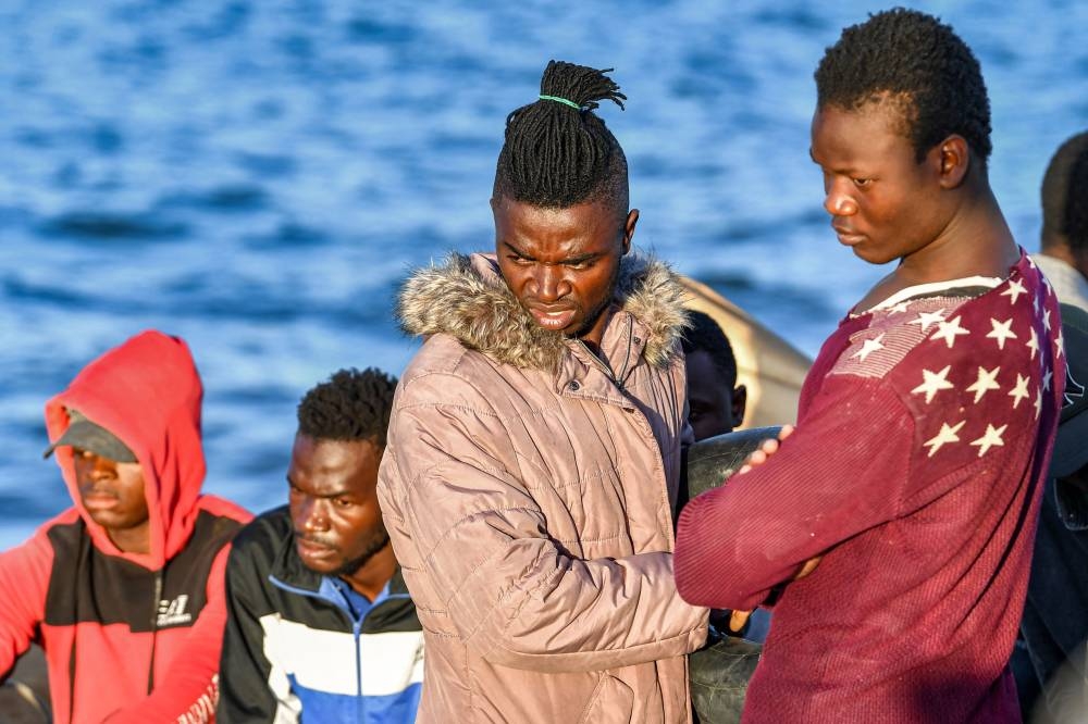 Migrants from sub-Saharan Africa look on after being rescued by the Tunisian National Guard at sea about 50 nautical miles in the Mediterranean sea off the coast of Tunisia’s central city of Sfax on October 4, 2022. — AFP pic
