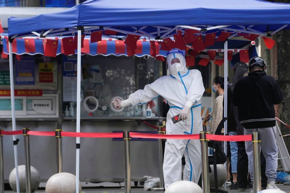 A worker in a protective suit stands at a nucleic acid testing site in Shanghai, China October 11, 2022. ― Reuters pic