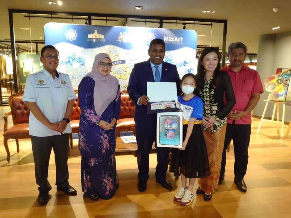 K. Raven Kumar (centre) presents certificates to a participant of a creativity competition organised by MuzArt International at the Yayasan Warisan Johor complex in Johor Baru October 19, 2022. — Picture by Ben Tan