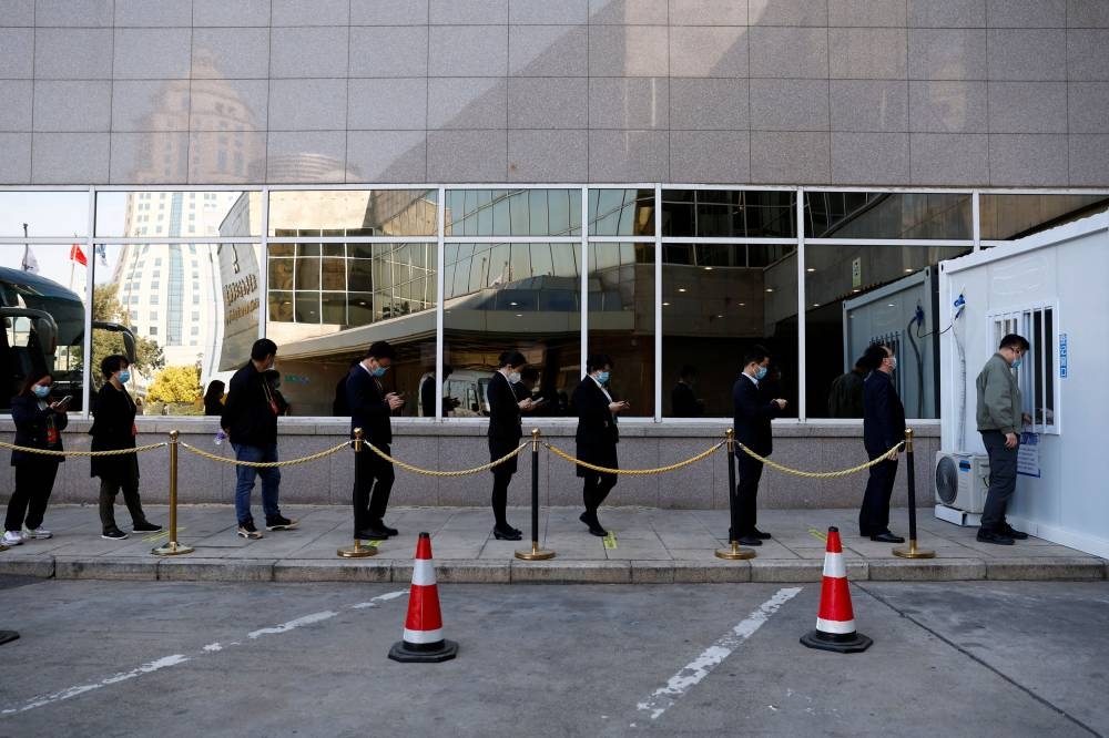 People line up at a nucleic acid testing booth to get tested for Covid-19 in Beijing, China October 19, 2022. ― Reuters pic 