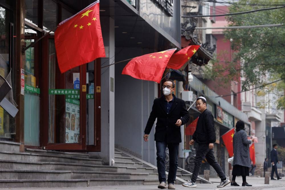 Chinese national flags fly in a street as the 20th National Congress of the Communist Party of China continues in Beijing, October 20, 2022. — Reuters pic