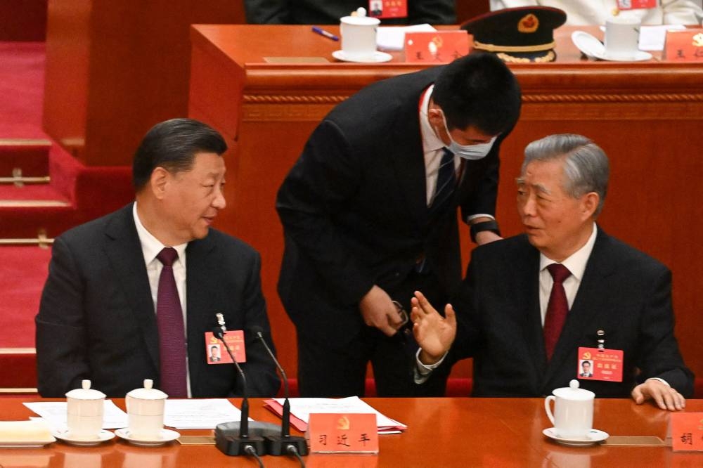 China’s President Xi Jinping (left) looks at former president Hu Jintao during the closing ceremony of the 20th Chinese Communist Party’s Congress at the Great Hall of the People in Beijing on October 22, 2022. — AFP pic