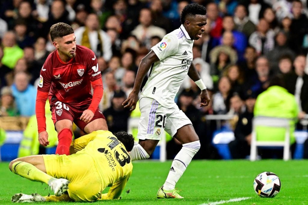 Real Madrid's Brazilian forward Vinicius Junior (right) fights for the ball with Sevilla's Spanish defender Jose Angel Carmona (left) and Sevilla's Moroccan goalkeeper Yassine Bounou ‘Bono’ (down) during the Spanish league football match between Real Madrid CF and Sevilla FC at the Santiago Bernabeu stadium in Madrid, on October 22, 2022. — AFP pic