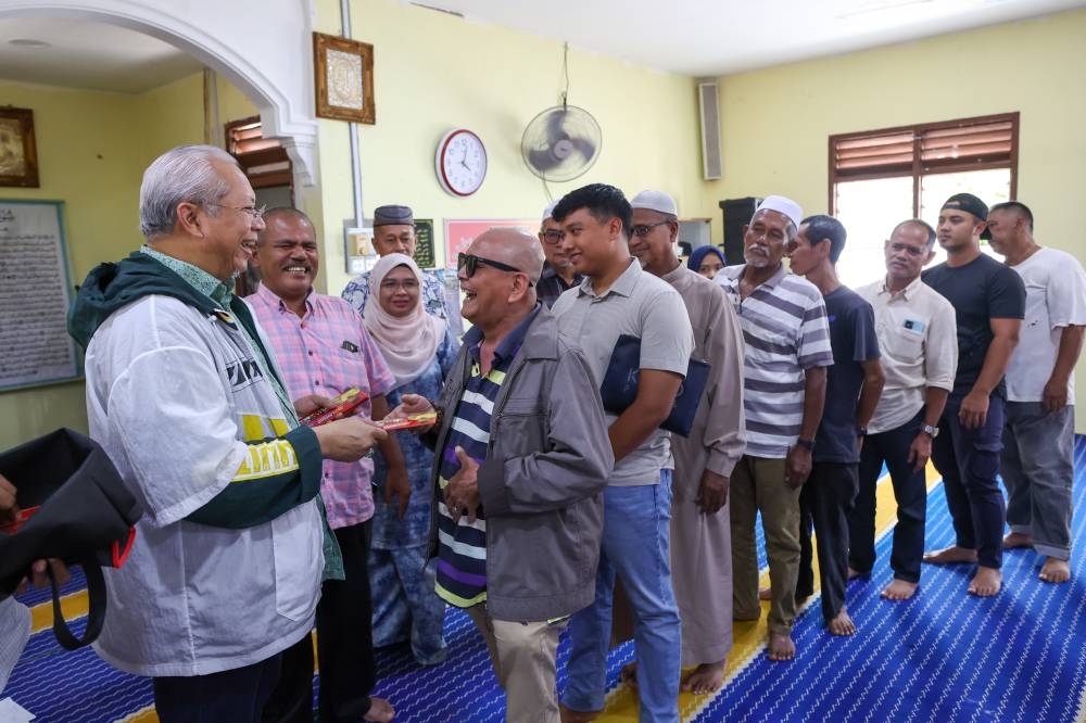 Communications and Multimedia Minister Tan Sri Annuar Musa hands over assistance to 212 families in the Keterah constituency who were affected by a recent storm in Kota Baru October 23, 2022. — Bernama pic