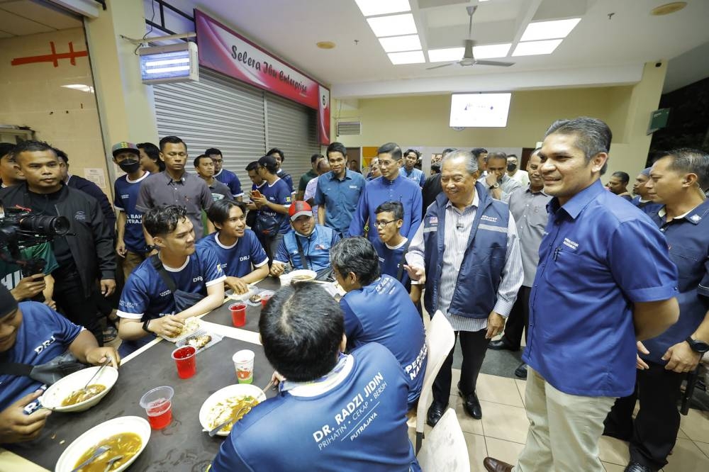 PN chairman Tan Sri Muhyiddin Yassin, who is also Bersatu president, talks to Putrajaya residents at the ‘Jelajah Prihatin Parlimen Putrajaya’ programme in Putrajaya, October 26, 2022. With him is Bersatu vice-president Datuk Mohd Radzi Md Jidin. — Bernama pic 