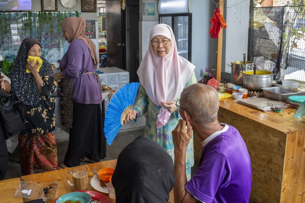 Datuk Seri Dr Wan Azizah Wan Ismail shares a light moment with local residents at Medan Selera Desa Tun Razak in Kuala Lumpur, October 27, 2022. — Picture by Shafwan Zaidon