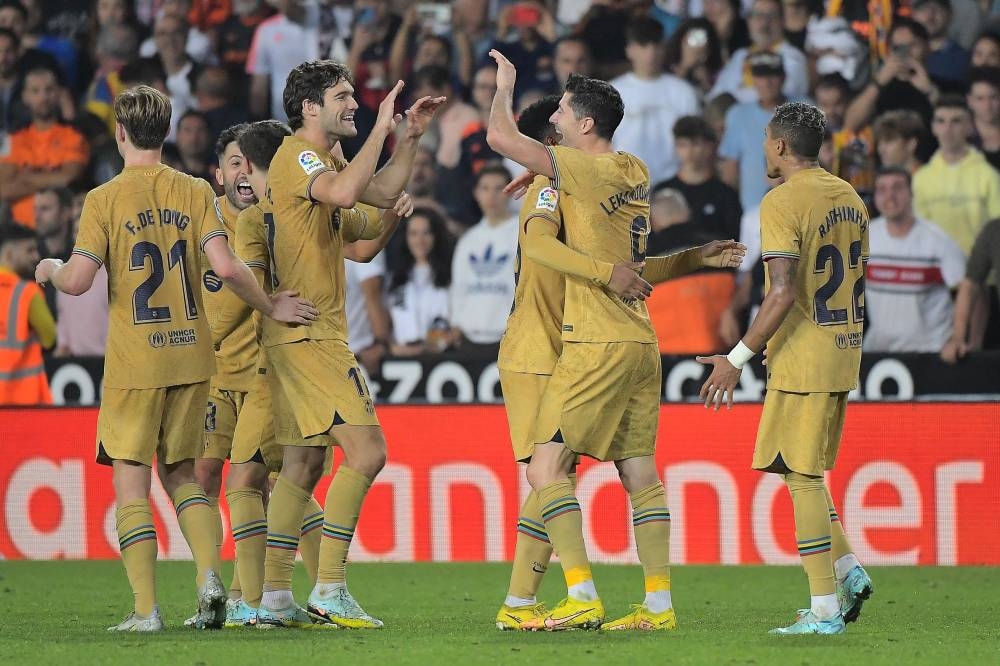 Barcelona's Polish forward Robert Lewandowski celebrates with teammates after scoring his team's first goal during the Spanish league football match between Valencia CF and FC Barcelona at the Mestalla stadium in Valencia on October 29, 2022. — AFP pic