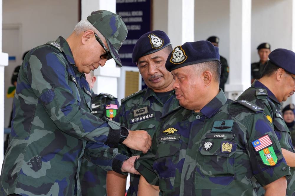 Inspector-General of Police Tan Sri Acryl Sani Abdullah Sani pins a Tiger Platoon badge on Johor police chief Datuk Kamarul Zaman Mamat (right) at the closing ceremony of the GOF’s Tiger Platoon Basic Course at the 6th GOF Battalion Camp in Johor, October 30, 2022. — Bernama pic 