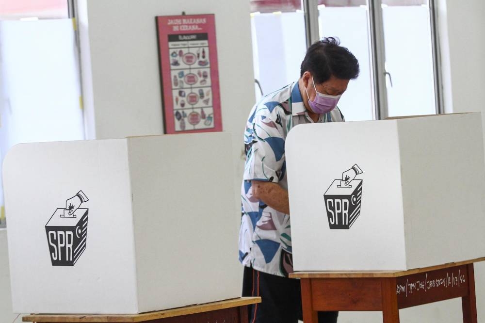 Voters cast their ballot at the SMK Sri Muar polling station in Muar, Johor March 12, 2022. -— Picture by Hari Anggara