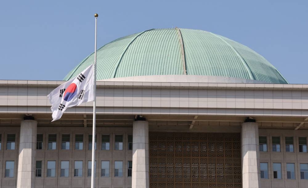 A South Korean national flag flies at half-mast at the National Assembly hall to mourn the victims of a stampede during Halloween festivities that killed and injured many people at the popular Itaewon district in Seoul, South Korea, in this image released by Yonhap on October 30, 2022. — Yonhap pic via Reuters