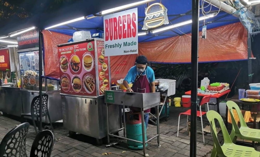 Independent rescuer Ong Siew Hiang sells burgers at Bandar Sunway to subsidise her rescue work. — Picture via Facebook/ Jeffrey Teh