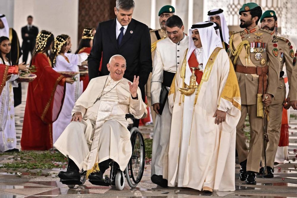 Pope Francis (centre to left) is escorted by Bahrain's King Hamad bin Isa al-Khalifa (centre to right) as he leaves the Royal Palace in the capital Manama on November 3, 2022. — AFP pic