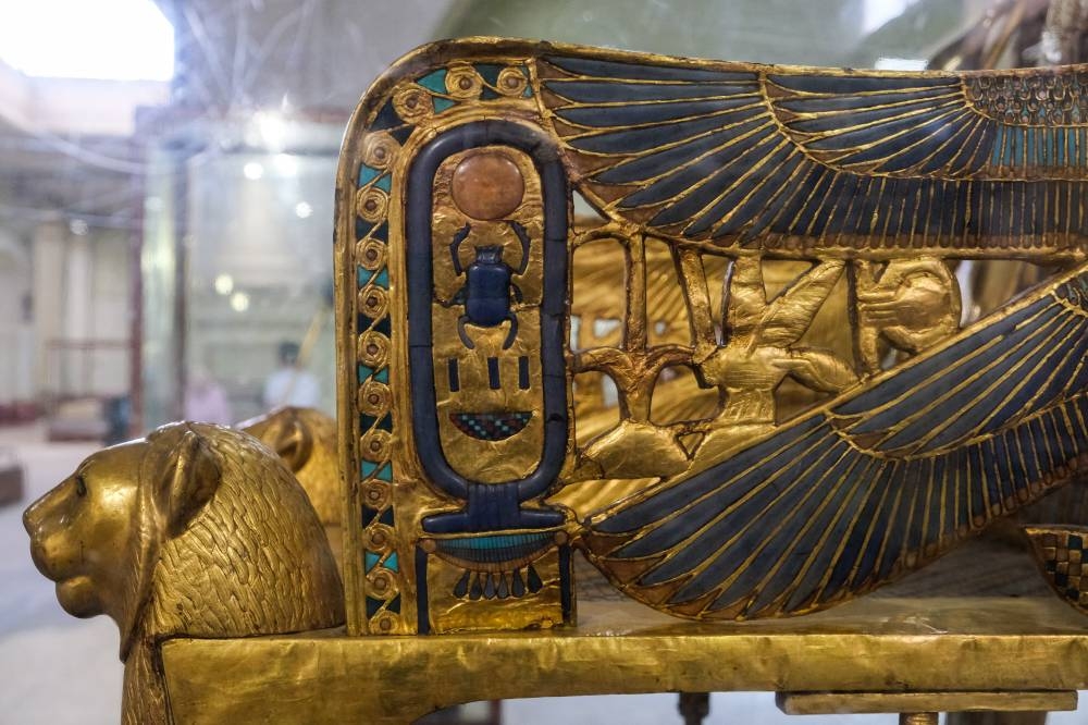 This file photo taken on May 03, 2022 This picture taken on May 3, 2022, shows a view of the gilded throne of the ancient Egyptian New Kingdom Pharaoh Tutankhamun (1334-1325 BC), found in 1922 at his tomb in Luxor and on display, at the Egyptian Museum in the capital Cairo, this side showing the cartouche depicting his throne name 