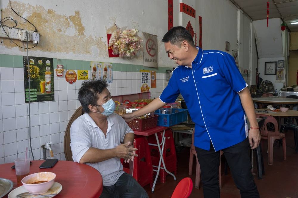 Barisan Nasional Alor Setar candidate, Tan Chee Hiong greets a local resident during a walkabout session in Alor Setar, Kedah November 7, 2022. 